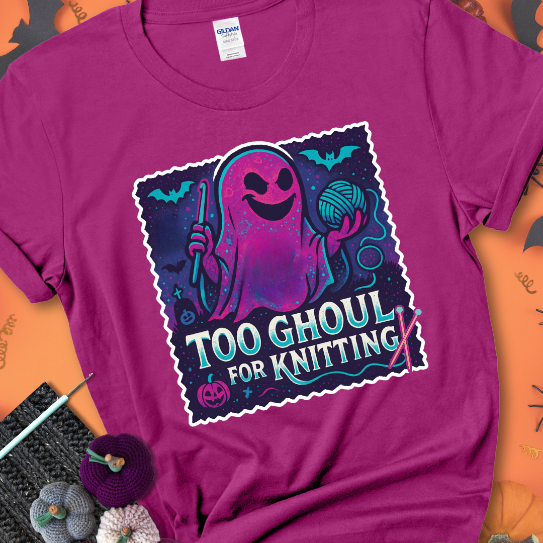 Antique Heliconia t-shirt with a ghost holding a crochet hook and ball of yarn, with the phrase “Too Ghoul for Knitting” in purple, teal, and white.
