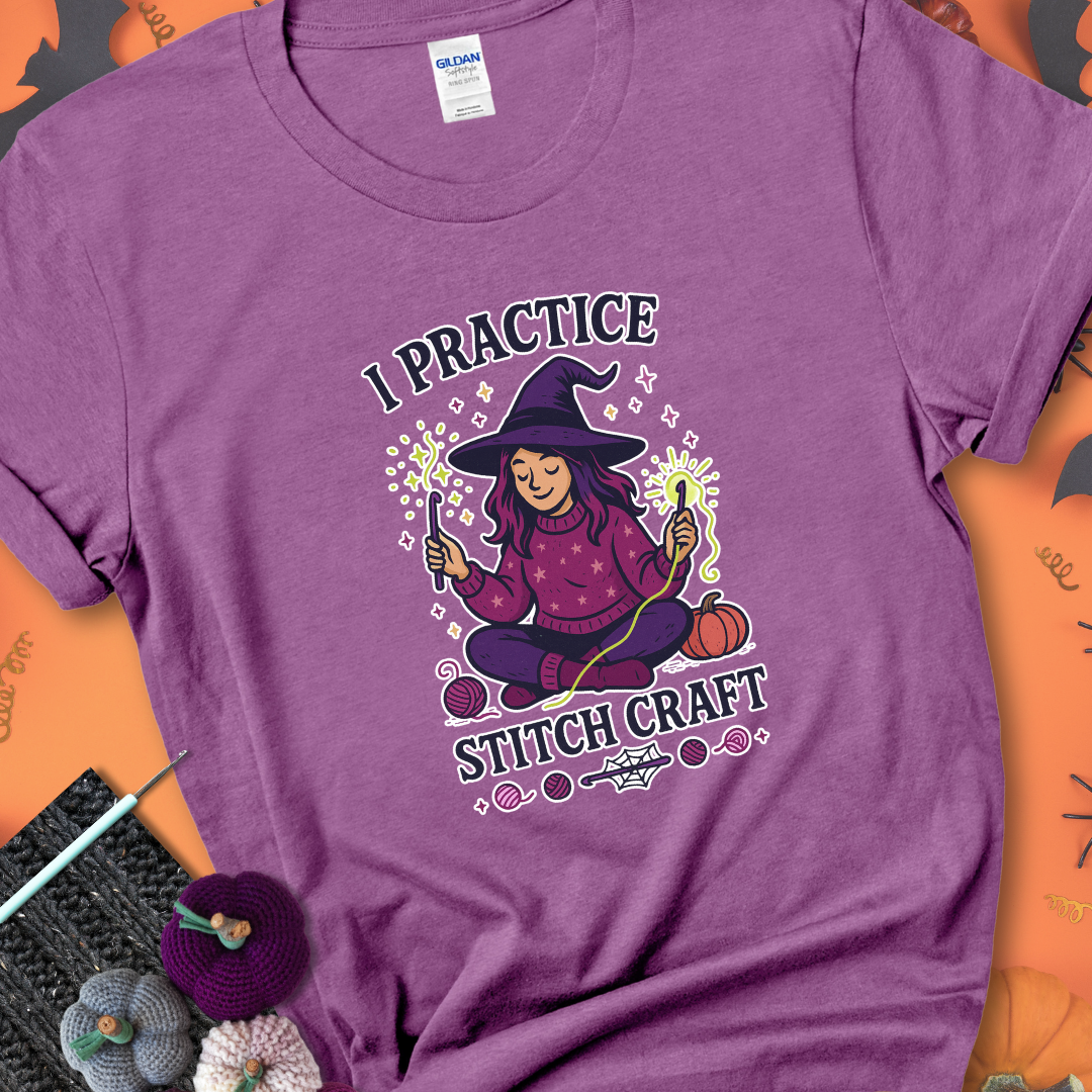 Heather Radiant Orchid t-shirt with a witchy crocheter conjuring glowing yarn with crochet hooks, surrounded by stars and pumpkins, with the phrase “I Practice Stitch Craft.”