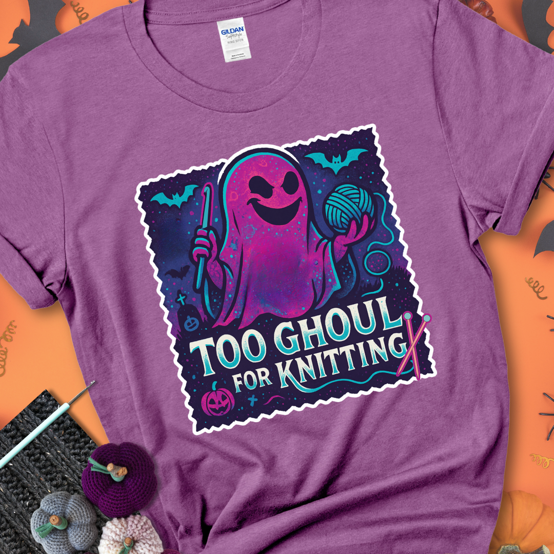Heather Radiant Orchid t-shirt with a ghost holding a crochet hook and ball of yarn, with the phrase “Too Ghoul for Knitting” in purple, teal, and white.