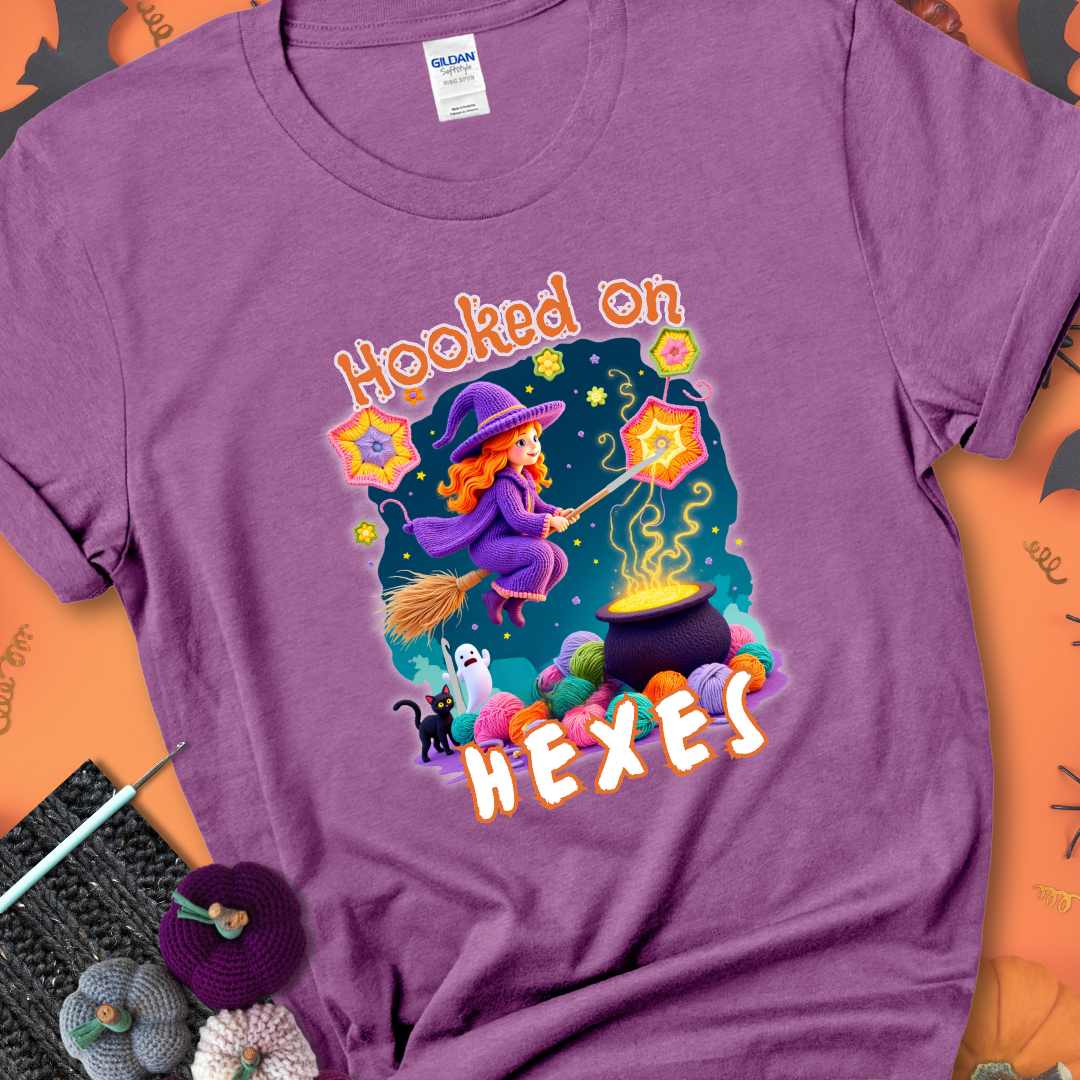 Heather Radiant Orchid t-shirt with stars, hexagon motifs, and a crochet hook, with text reading “Hooked on Hexes.”