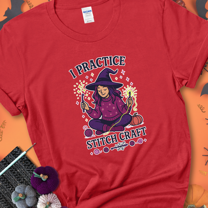 Red t-shirt with a witchy crocheter conjuring glowing yarn with crochet hooks, surrounded by stars and pumpkins, with the phrase “I Practice Stitch Craft.”