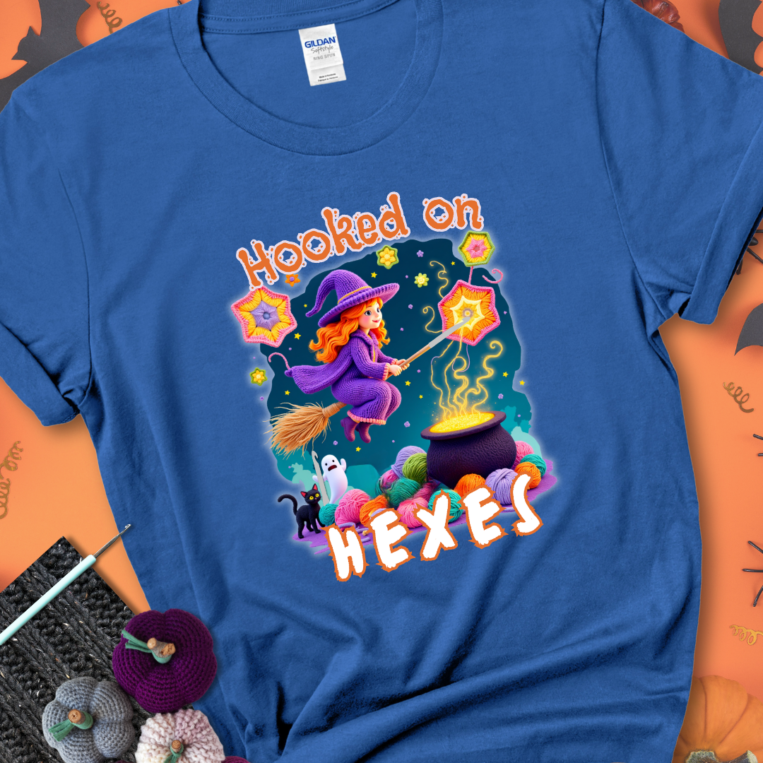 Royal t-shirt with stars, hexagon motifs, and a crochet hook, with text reading “Hooked on Hexes.”