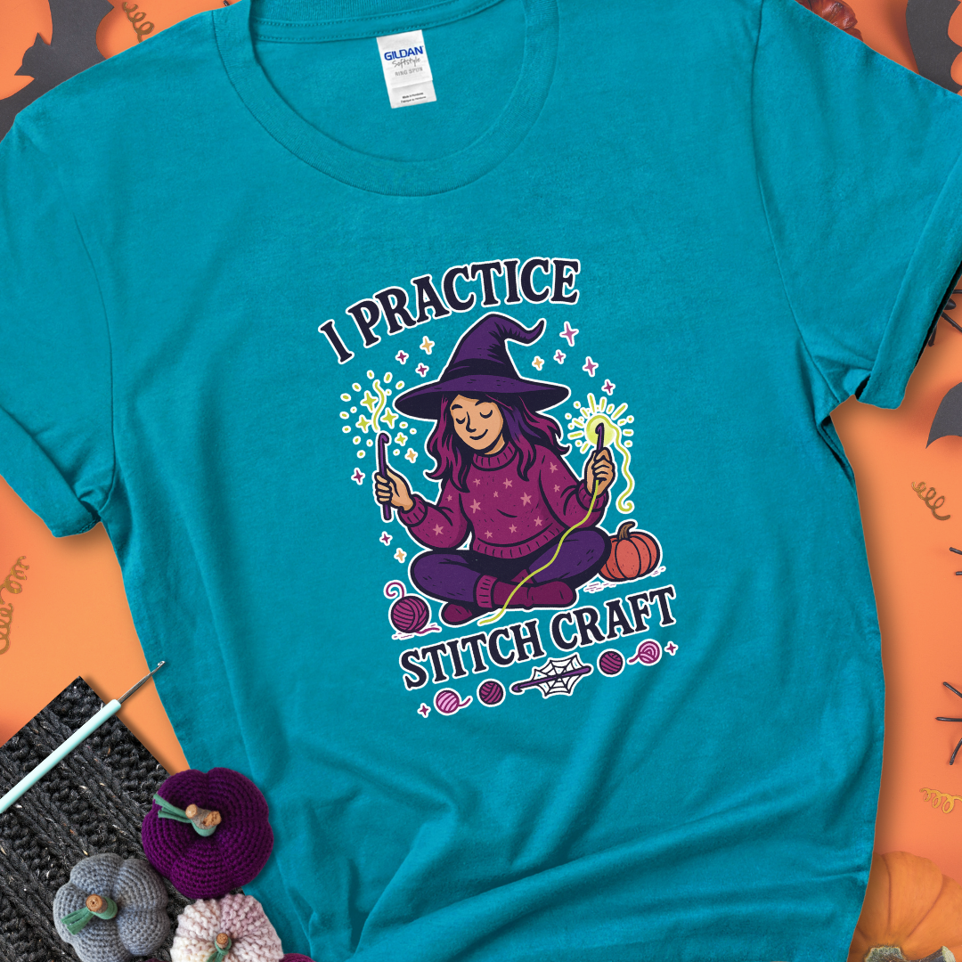 Tropical Blue t-shirt with a witchy crocheter conjuring glowing yarn with crochet hooks, surrounded by stars and pumpkins, with the phrase “I Practice Stitch Craft.”