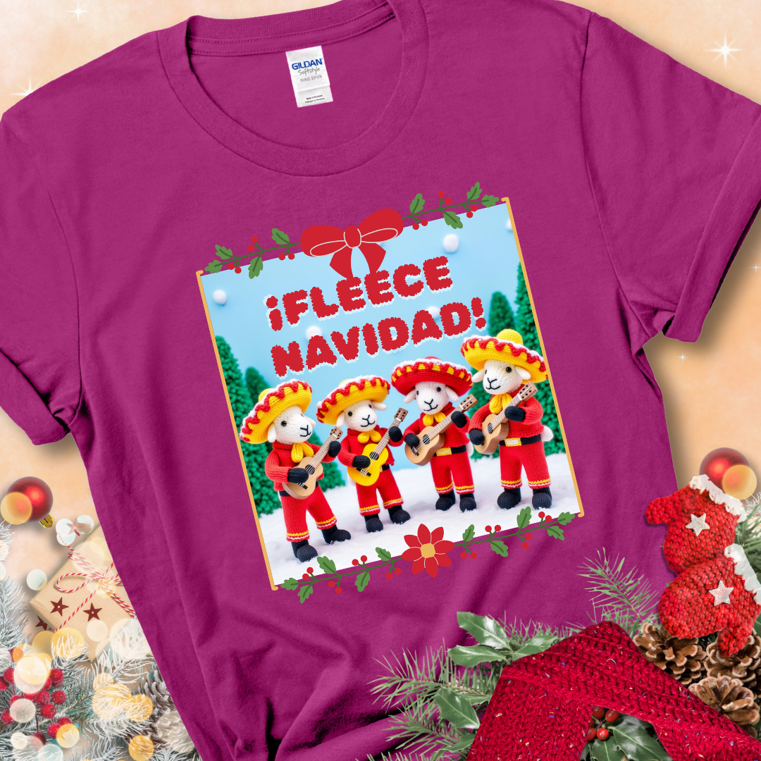 Antique Heliconia t-shirt with four crocheted sheep in red mariachi outfits holding guitars, standing in a snowy scene under the phrase “¡Fleece Navidad!”