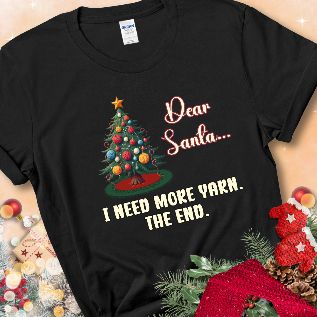 Black t-shirt with a Christmas tree decorated with yarn-ball ornaments and the stitched message “Dear Santa… I Need More Yarn. The End.”