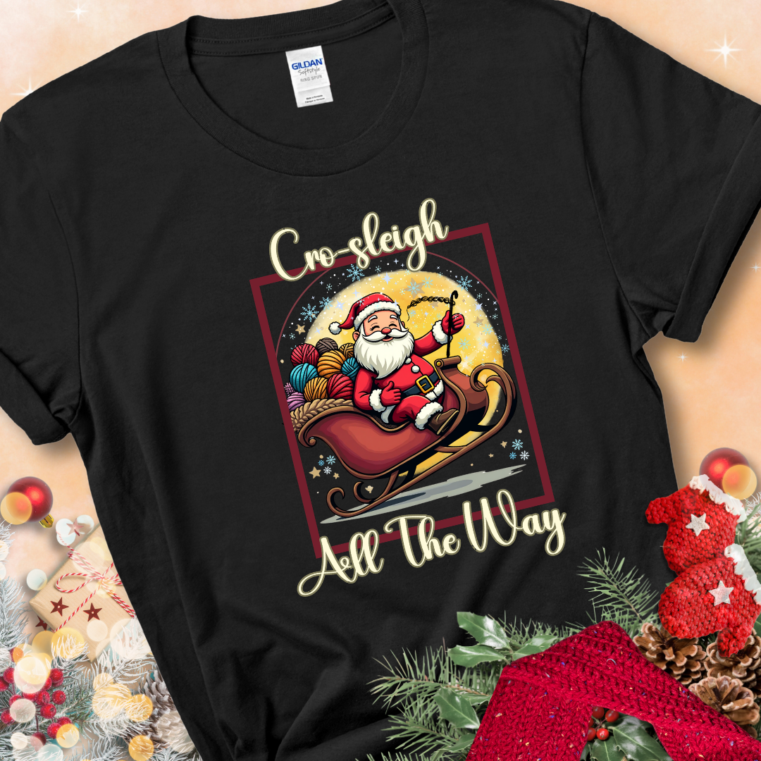 Black t-shirt with Santa riding in a sleigh overflowing with colorful yarn and the phrase “Cro-Sleigh All The Way.”