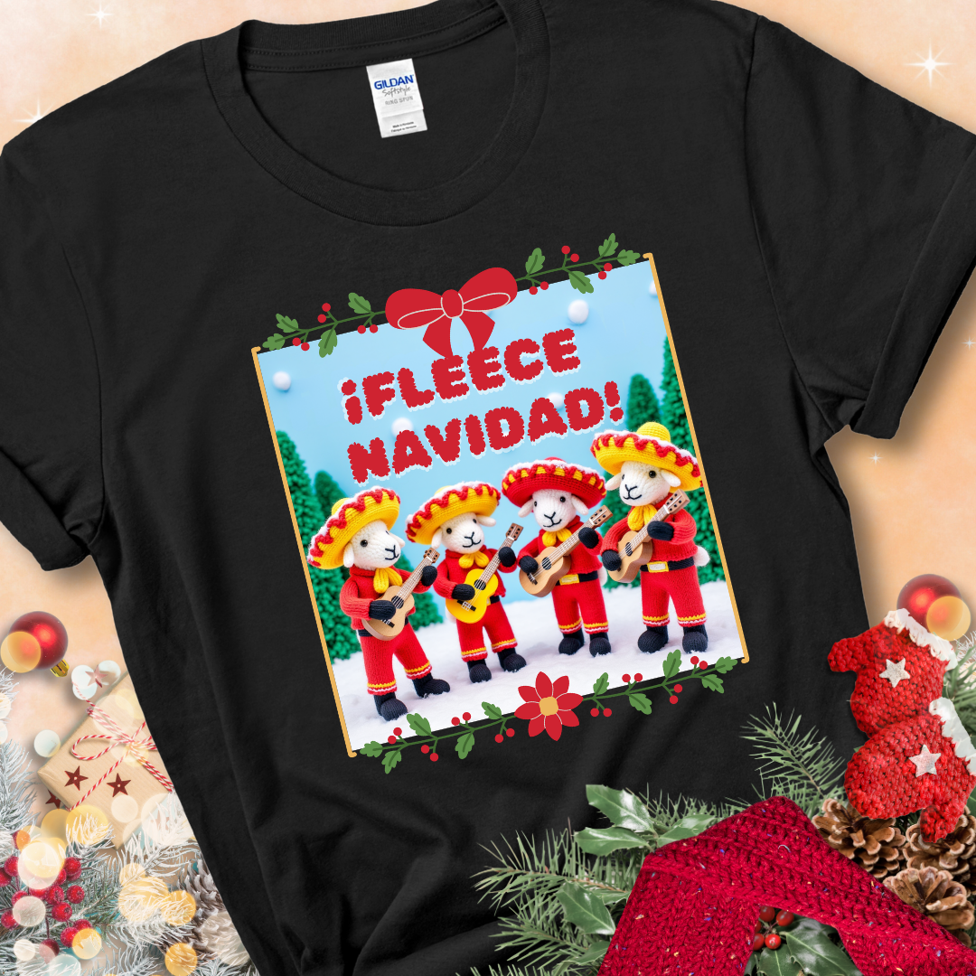 Black t-shirt with four crocheted sheep in red mariachi outfits holding guitars, standing in a snowy scene under the phrase “¡Fleece Navidad!”