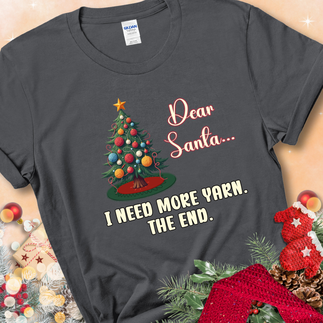 Charcoal t-shirt with a Christmas tree decorated with yarn-ball ornaments and the stitched message “Dear Santa… I Need More Yarn. The End.”