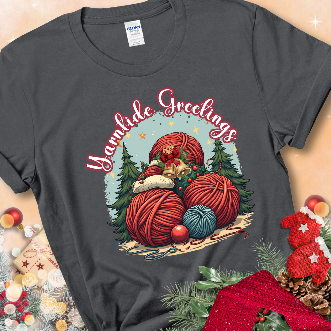 Charcoal t-shirt with red yarn balls, holiday greenery, bells, and the phrase “Yarntide Greetings.”
