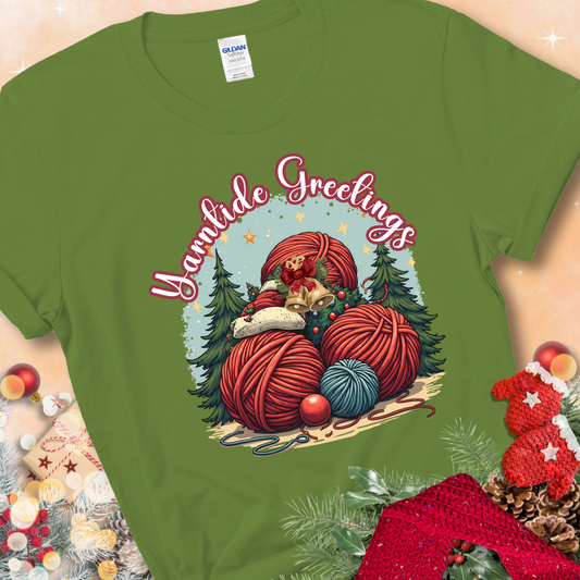 Kiwi t-shirt with red yarn balls, holiday greenery, bells, and the phrase “Yarntide Greetings.”