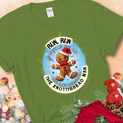 Kiwi t-shirt with a crocheted gingerbread man in a Santa hat and the phrase “You Can’t Out-Stitch the Knottybread Man.”