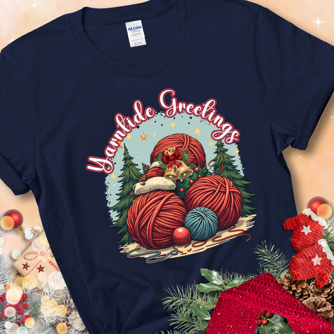 Navy t-shirt with red yarn balls, holiday greenery, bells, and the phrase “Yarntide Greetings.”