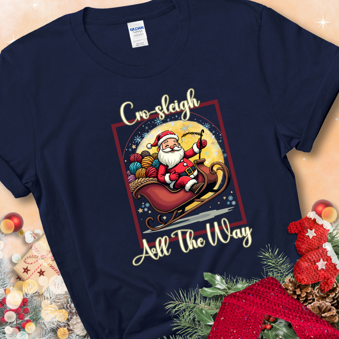 Navy Blue t-shirt with Santa riding in a sleigh overflowing with colorful yarn and the phrase “Cro-Sleigh All The Way.”