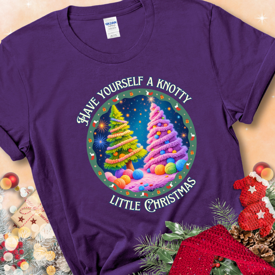 Purple t-shirt with two yarn-covered Christmas trees wrapped in colorful strands of yarn, encircled by the phrase “Have Yourself A Knotty Little Christmas.”
