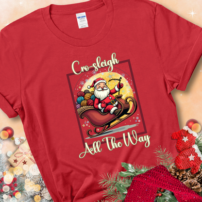 Red t-shirt with Santa riding in a sleigh overflowing with colorful yarn and the phrase “Cro-Sleigh All The Way.”