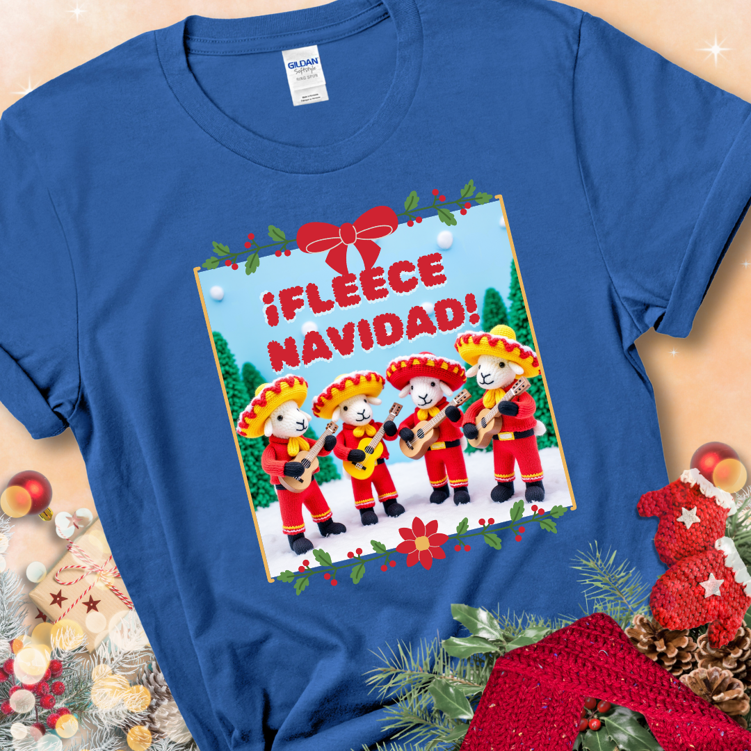 Royal Blue t-shirt with four crocheted sheep in red mariachi outfits holding guitars, standing in a snowy scene under the phrase “¡Fleece Navidad!”