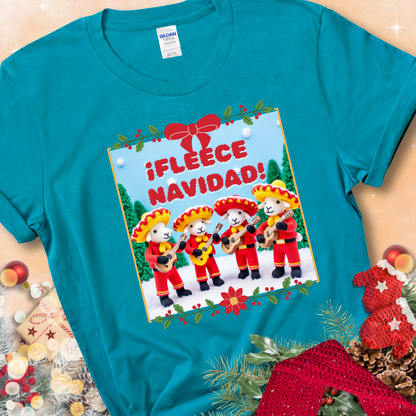Tropical Blue t-shirt with four crocheted sheep in red mariachi outfits holding guitars, standing in a snowy scene under the phrase “¡Fleece Navidad!”