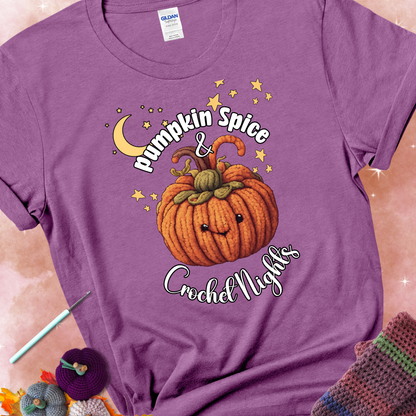 Heather radiant orchid t-shirt with a smiling pumpkin crocheted with yarn texture, surrounded by stars and a crescent moon. Text reads “Pumpkin Spice & Crochet Nights.”