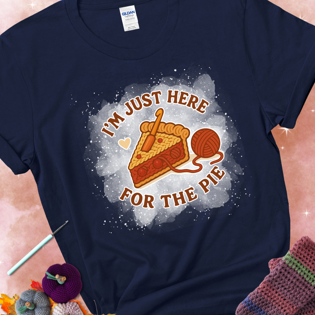 Navy t-shirt with a stitched slice of cherry pie with yarn-inspired filling and the phrase “I’m Just Here for the Pie” in red, beige, and cream.