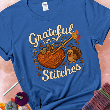 Royal t-shirt with a crochet hook stitching a heart-shaped pumpkin, surrounded by yarn and a small turkey, with the phrase “Grateful for the Stitches.”