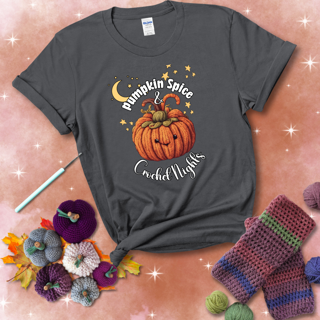 Smiling pumpkin crocheted with yarn texture, surrounded by stars and a crescent moon. Text reads “Pumpkin Spice & Crochet Nights” showing a dark grey tee with a festive Fall background