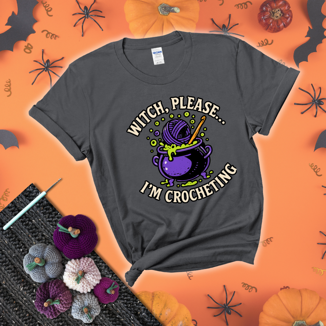 Put a spell on your stash Design reads 'Witch, Please… I’m Crocheting,' perfect crochet gift for yarn lovers showing a dark grey tee with a festive Halloween background