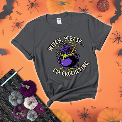 Put a spell on your stash Design reads 'Witch, Please… I’m Crocheting,' perfect crochet gift for yarn lovers showing a dark grey tee with a festive Halloween background