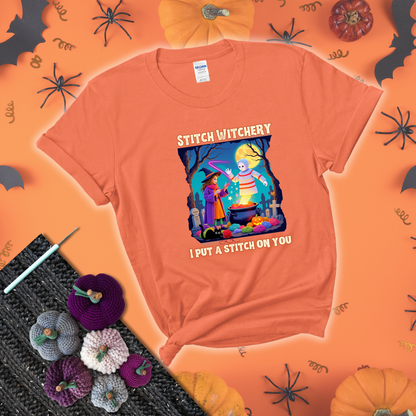 A Halloween scene with a young witch casting a yarn spell from a cauldron onto a floating crochet-ghost figure, under the phrase “I Put a Stitch on You” showing a light orange tee with a festive Halloween background