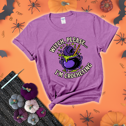 Put a spell on your stash Design reads 'Witch, Please… I’m Crocheting,' perfect crochet gift for yarn lovers showing a light purple tee with a festive Halloween background