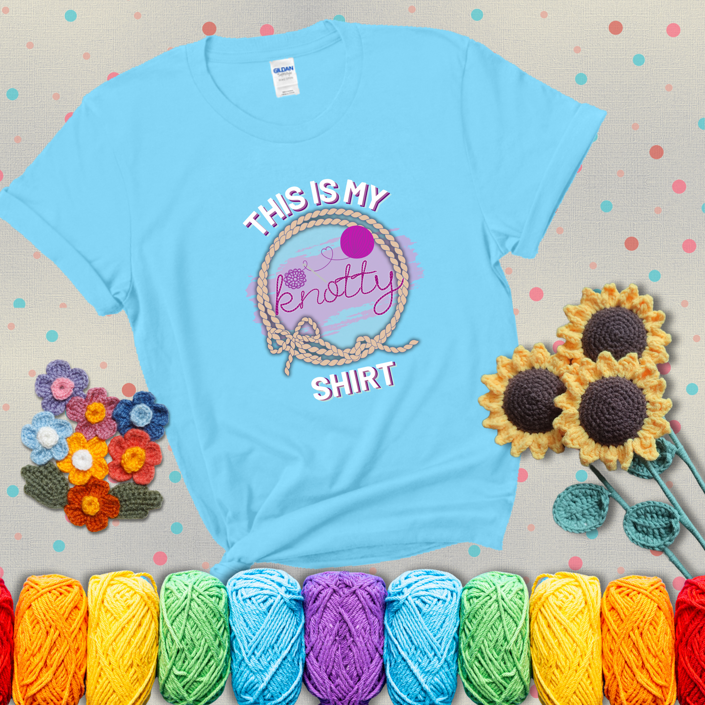 A playful design with the phrase "This is my knotty shirt" inside a rope circle, featuring a yarn ball and a crochet hook forming the word "knotty" showing a light blue tee with grey sunflower background