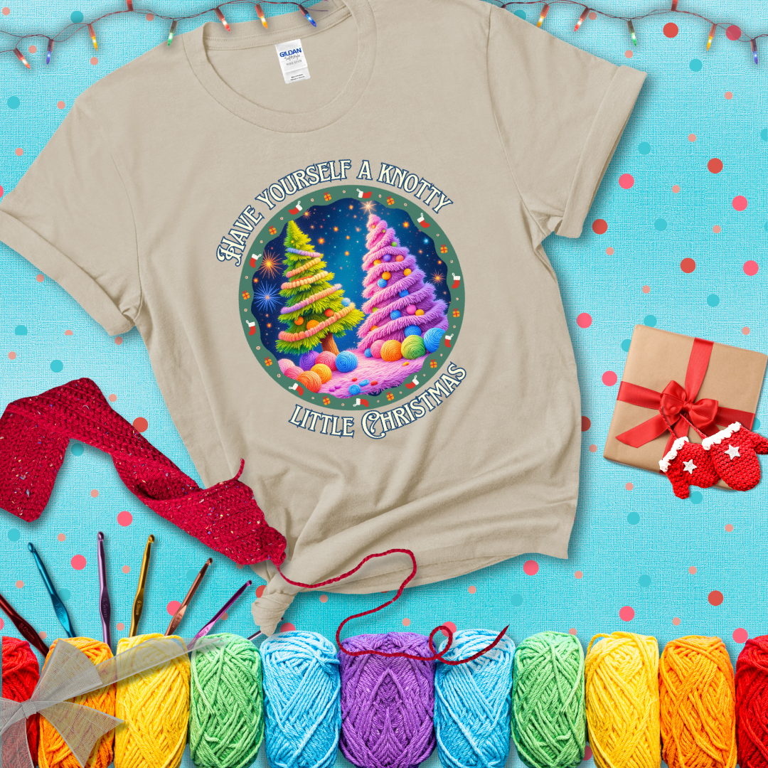 Two yarn-covered Christmas trees wrapped in colorful strands of yarn, with the phrase "Have Yourself a Knotty Little Christmas" encircling the scene showing a beige tee with a festive Christmas background