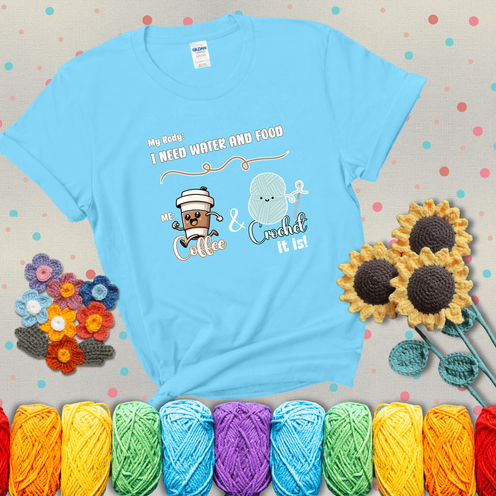 Design reads “My body: I need water and food. Me: Coffee & Crochet it is,” with a smiling coffee cup and yarn ball characters showing a light blue tee with grey sunflower background