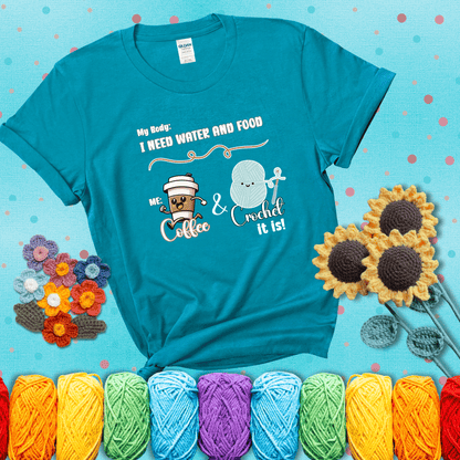 Design reads “My body: I need water and food. Me: Coffee & Crochet it is,” with a smiling coffee cup and yarn ball characters showing a blue-green tee with a teal sunflower background