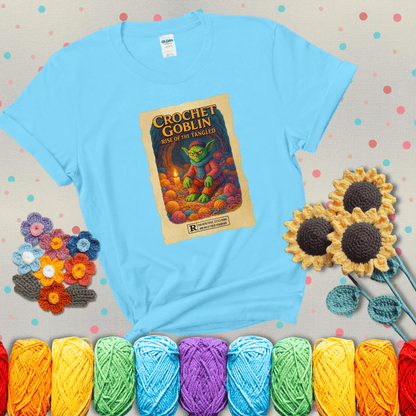 Crochet goblin surrounded by chaotic yarn stash in a cave-like lair. Text reads: “Crochet Goblin: Rise of the Tangled.” A funny fantasy-style tee for yarn hoarders and goblin-mode crafters. showing a light blue tee with grey sunflower background