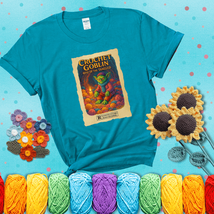 Crochet goblin surrounded by chaotic yarn stash in a cave-like lair. Text reads: “Crochet Goblin: Rise of the Tangled.” A funny fantasy-style tee for yarn hoarders and goblin-mode crafters. showing a blue-green tee with a teal sunflower background