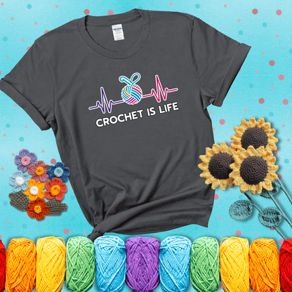 A heartbeat line with a colorful yarn ball and crochet hook in the center, with the words “Crochet is Life”, showing a dark grey tee with a teal sunflower background