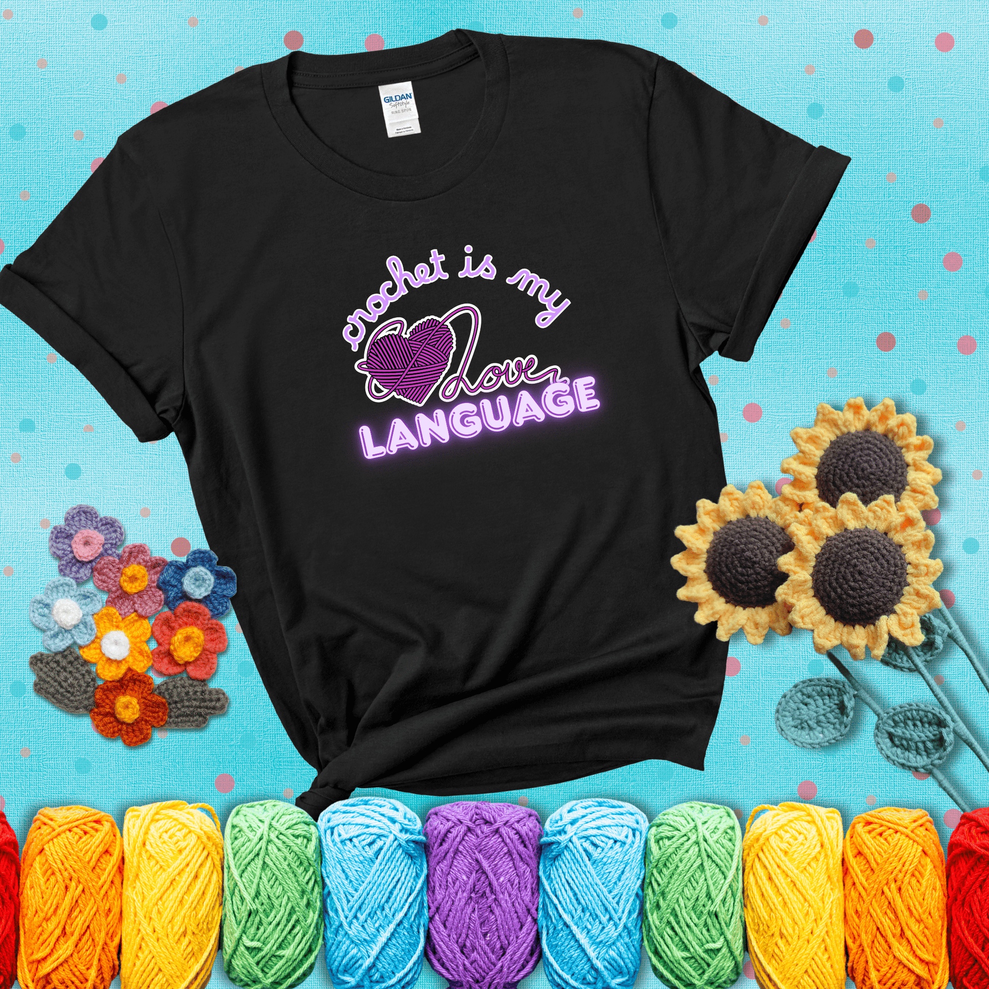 Say it with stitches Design reads 'Crochet Is My Love Language', perfect crochet gift for yarn lovers; showing a black tee with a teal sunflower background