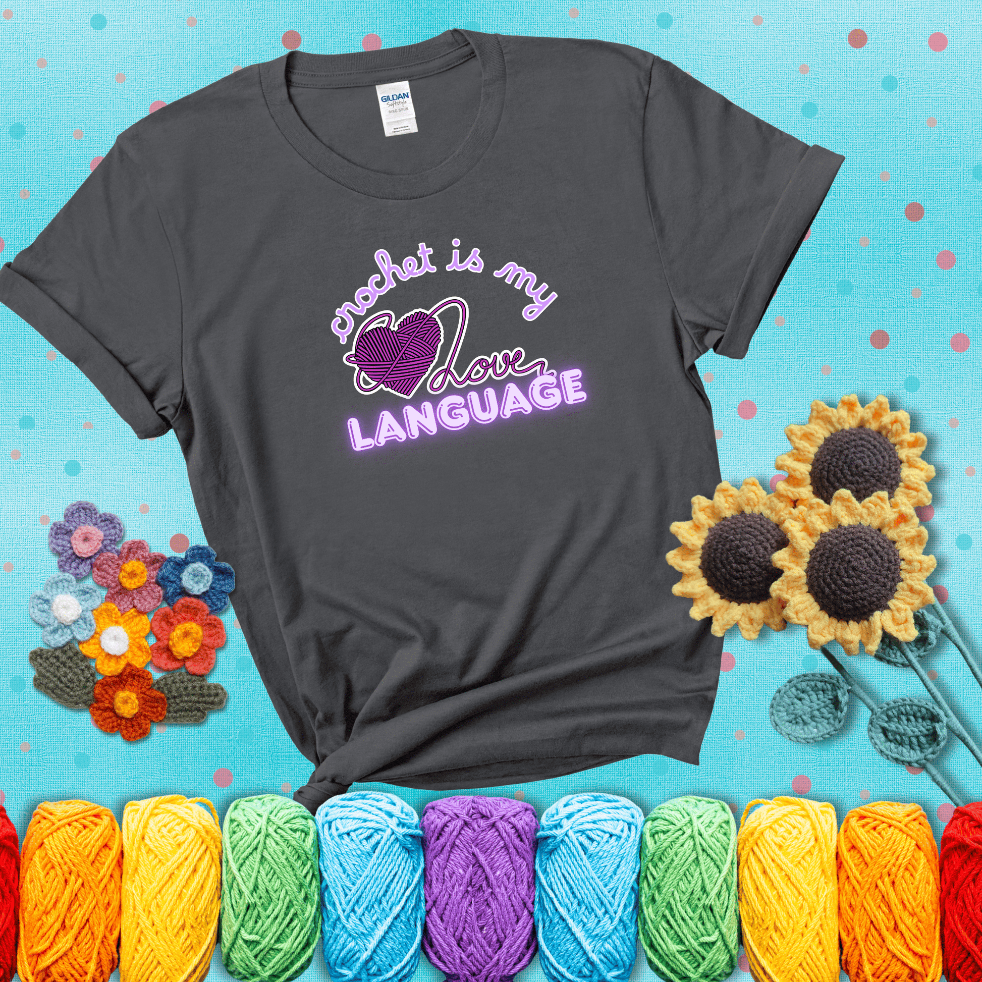 Say it with stitches Design reads 'Crochet Is My Love Language', perfect crochet gift for yarn lovers; showing a dark grey tee with a teal sunflower background