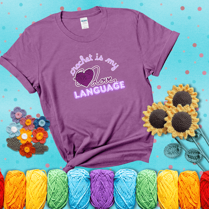 Say it with stitches Design reads 'Crochet Is My Love Language', perfect crochet gift for yarn lovers; showing a light purple tee with a teal sunflower background