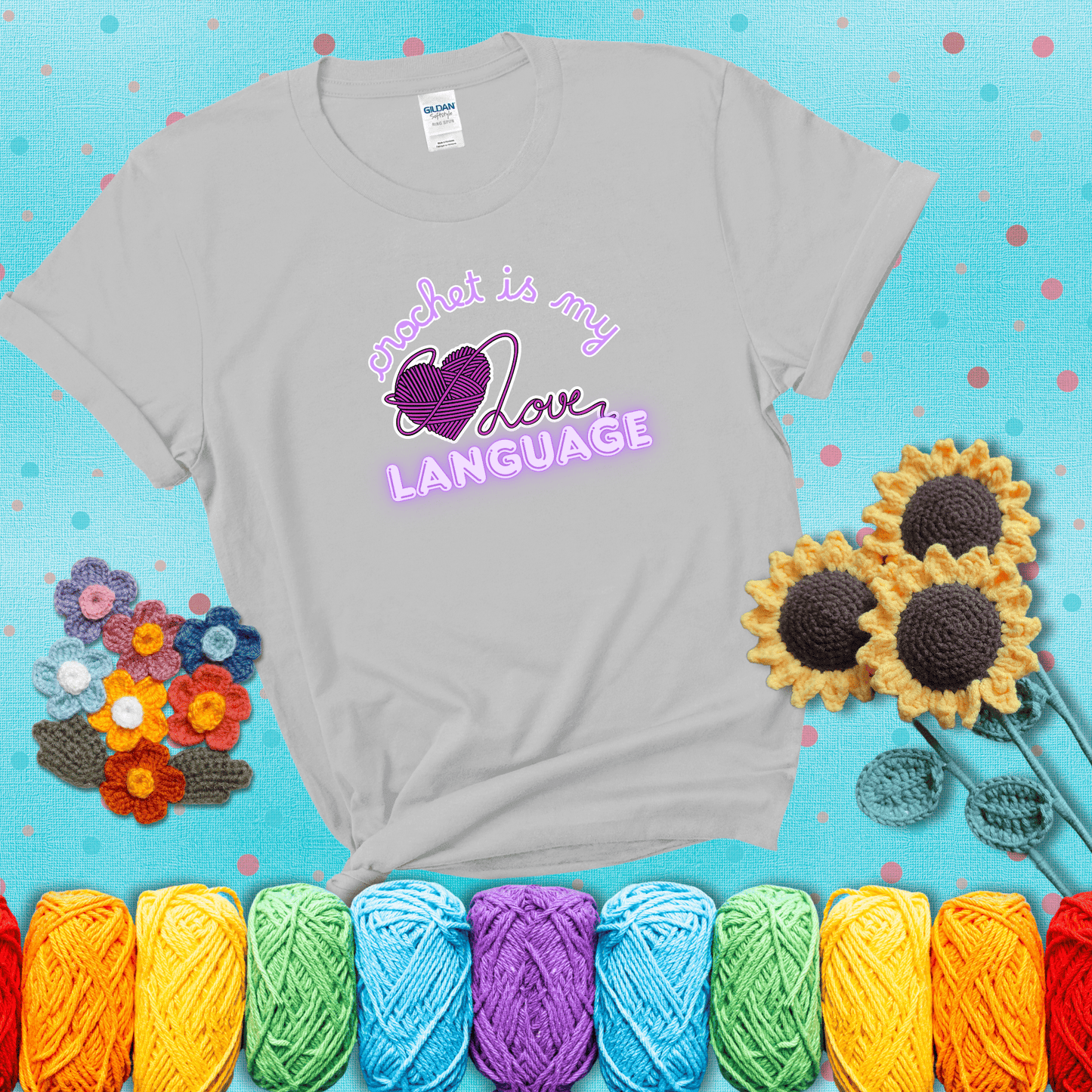 Say it with stitches Design reads 'Crochet Is My Love Language', perfect crochet gift for yarn lovers; showing a light grey tee with a teal sunflower background