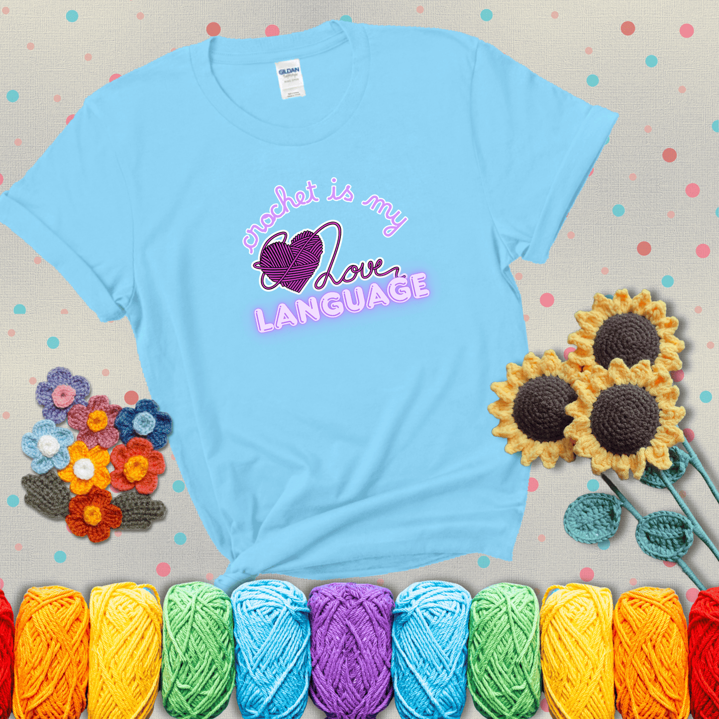 Say it with stitches Design reads 'Crochet Is My Love Language', perfect crochet gift for yarn lovers; showing a light blue tee with grey sunflower background