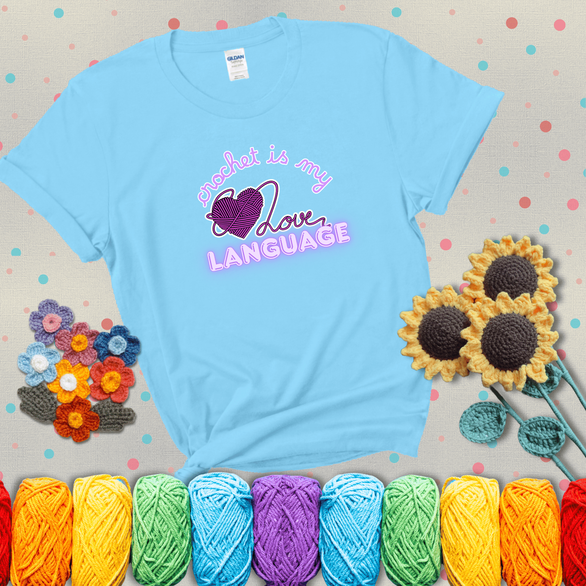 Say it with stitches Design reads 'Crochet Is My Love Language', perfect crochet gift for yarn lovers; showing a light blue tee with grey sunflower background