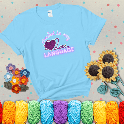 Say it with stitches Design reads 'Crochet Is My Love Language', perfect crochet gift for yarn lovers; showing a light blue tee with grey sunflower background