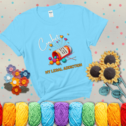 Orange prescription bottle spilling colorful yarn balls with text "Crochet – My Legal Addiction" and "Take as needed for maximum stress relief" showing a light blue tee with grey sunflower background