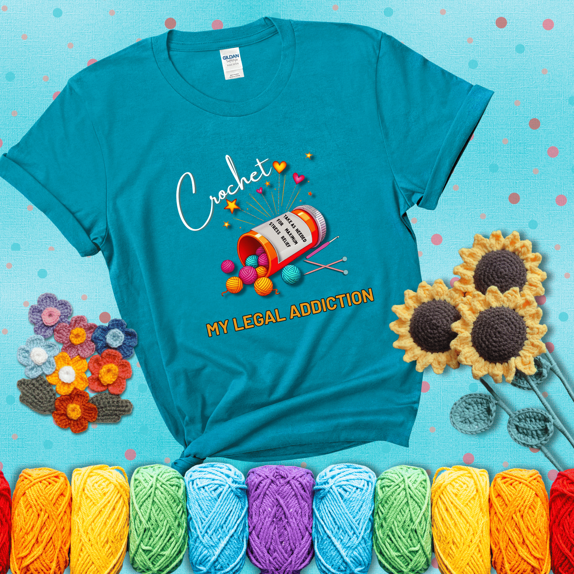 Orange prescription bottle spilling colorful yarn balls with text "Crochet – My Legal Addiction" and "Take as needed for maximum stress relief" showing a blue-green tee with a teal sunflower background