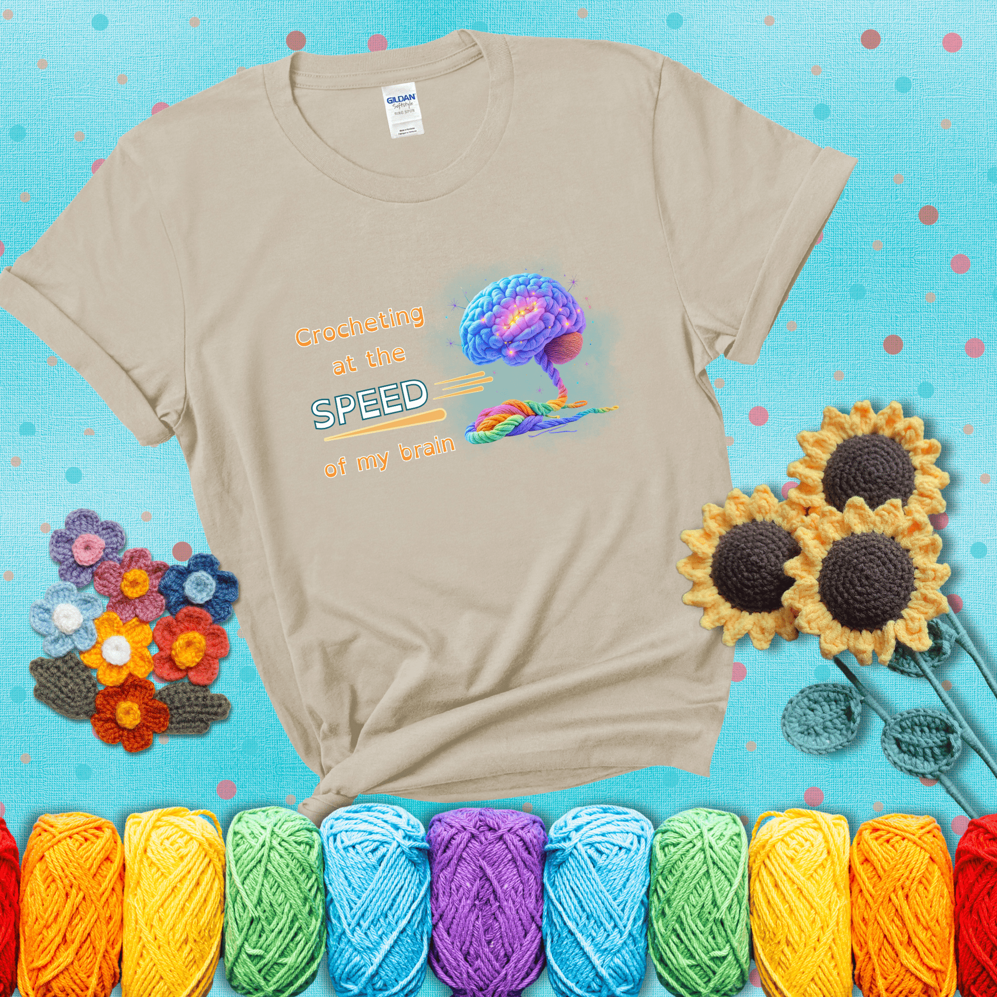 A glowing rainbow brain unravels into colorful yarn with the phrase “Crocheting at the speed of my brain;" showing a beige tee with a teal sunflower background