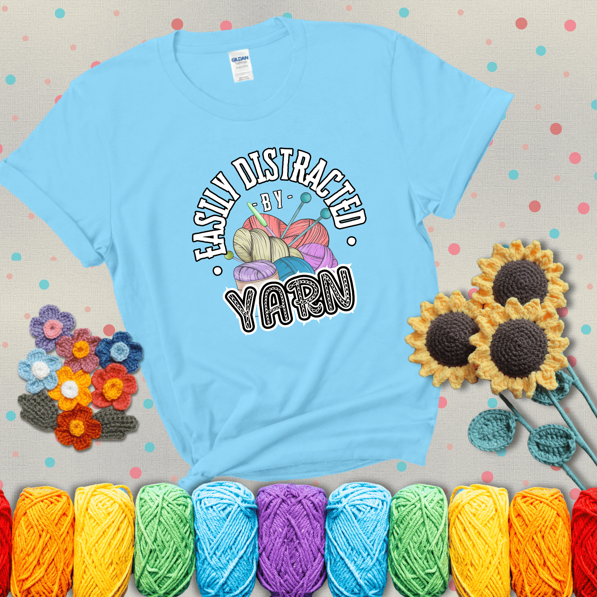 If yarn steals your focus every Design reads 'Easily Distracted By Yarn', perfect crochet gift for yarn lovers; showing a light blue tee with grey sunflower background