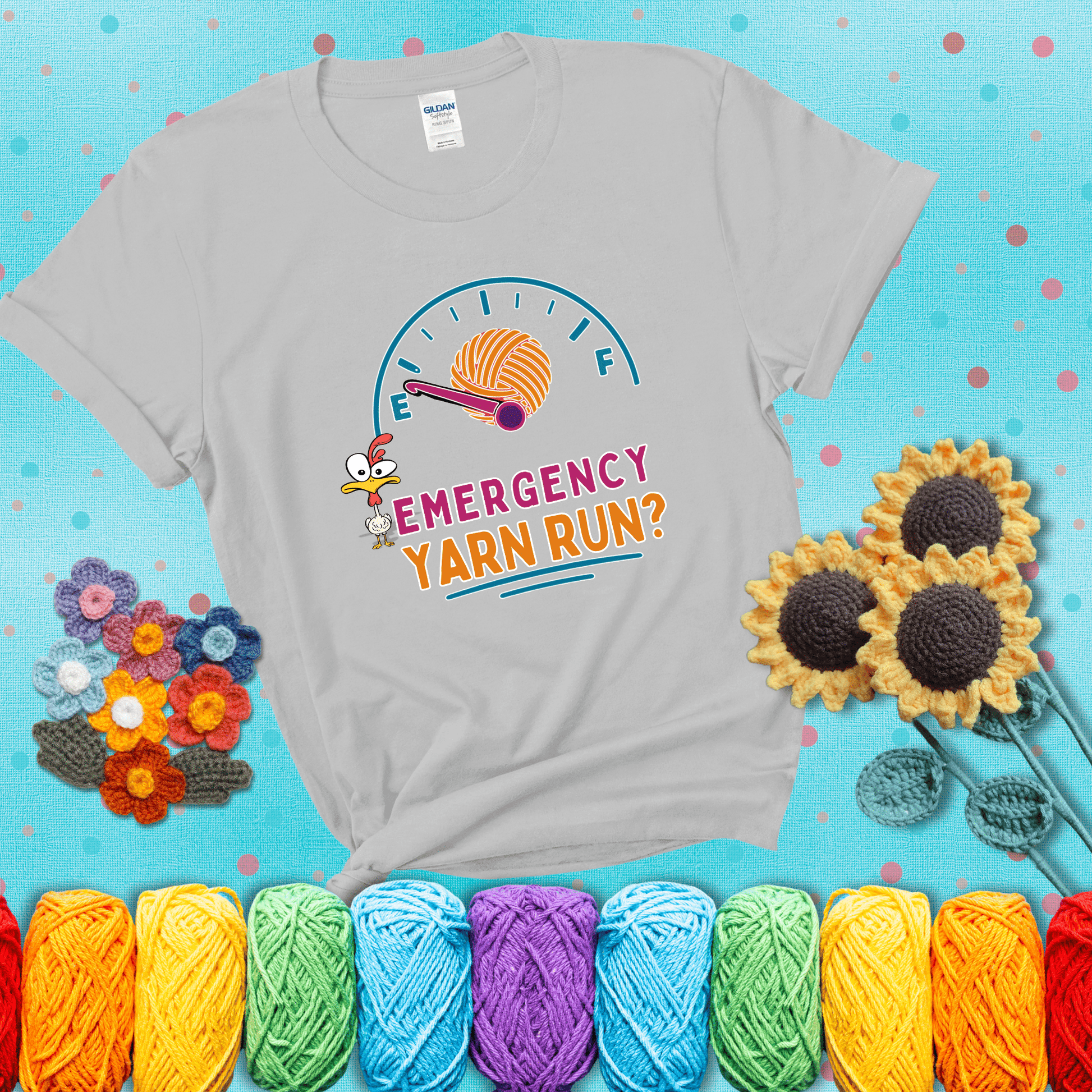 A fuel gauge with a ball of yarn as the needle pointing to empty, a frantic chicken, and the text “Emergency Yarn Run?” showing a light grey tee with a teal sunflower background