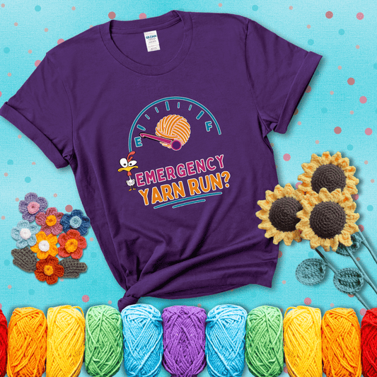 A fuel gauge with a ball of yarn as the needle pointing to empty, a frantic chicken, and the text “Emergency Yarn Run?” showing a purple tee with a teal sunflower background