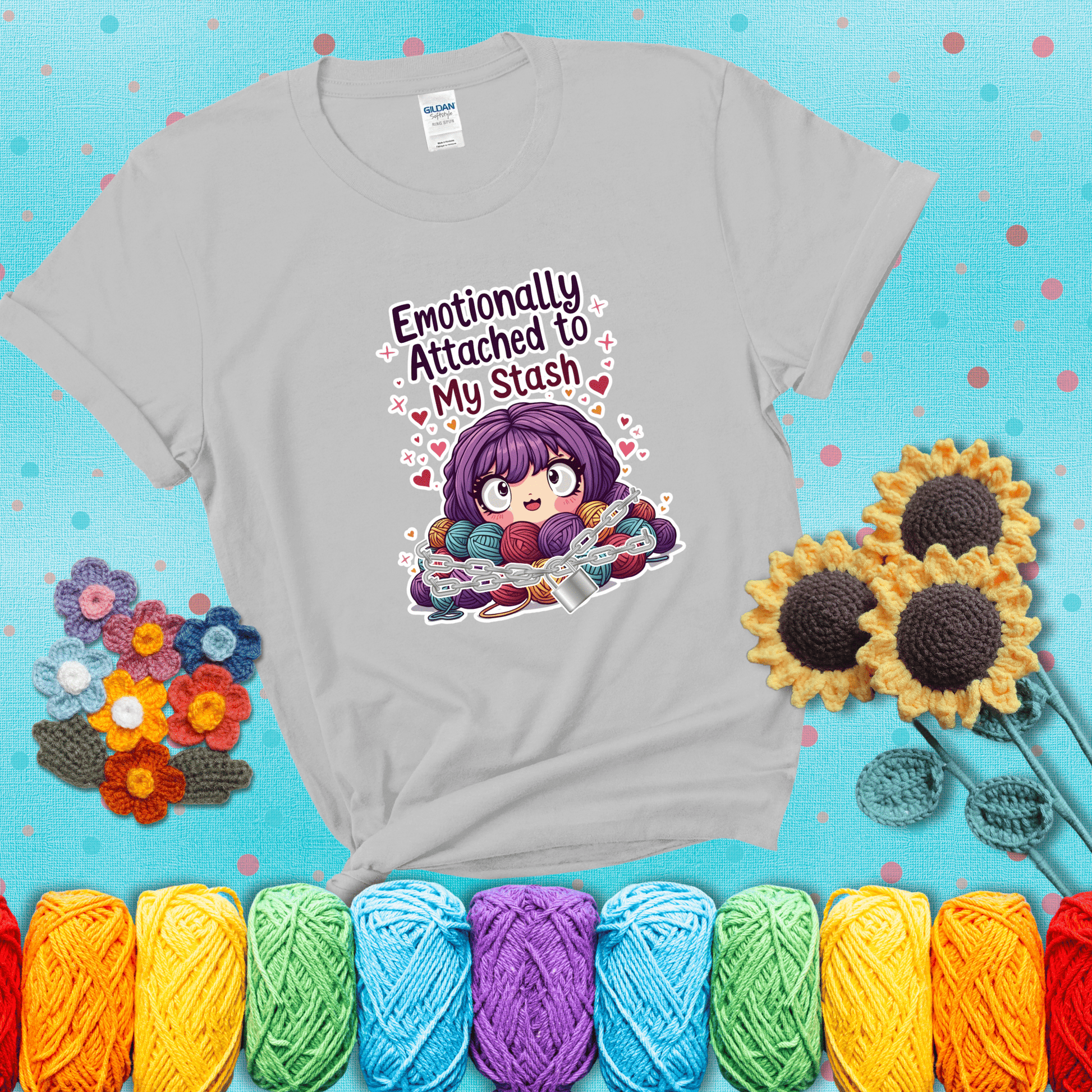 Rows of colorful yarn skeins stacked with playful text. Text reads: “Emotionally Attached to My Stash.” A humorous shirt for fiber lovers with growing collections, showing a light grey tee with a teal sunflower background